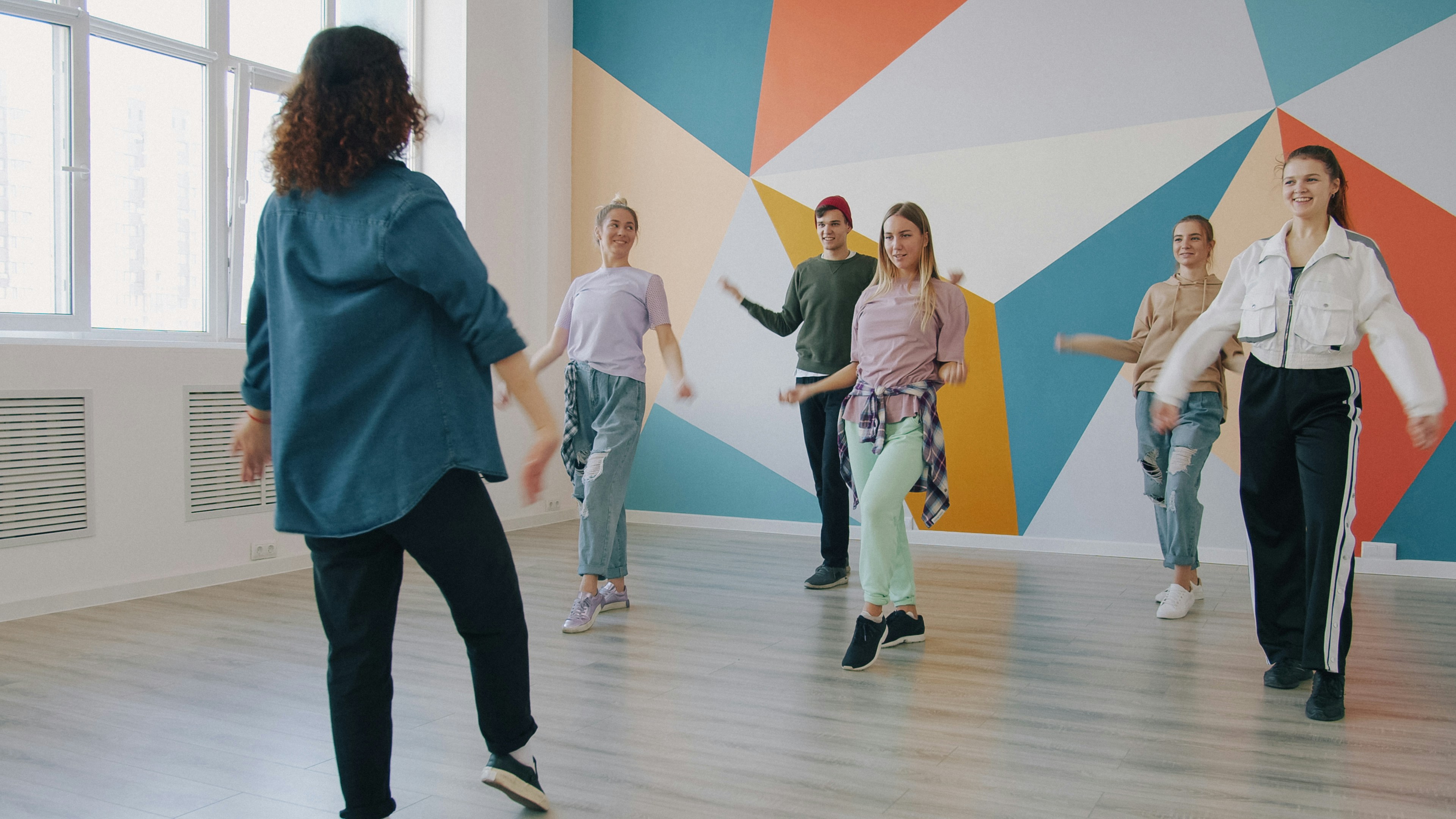 Dancer practicing alone at home using a phone as a visual guide